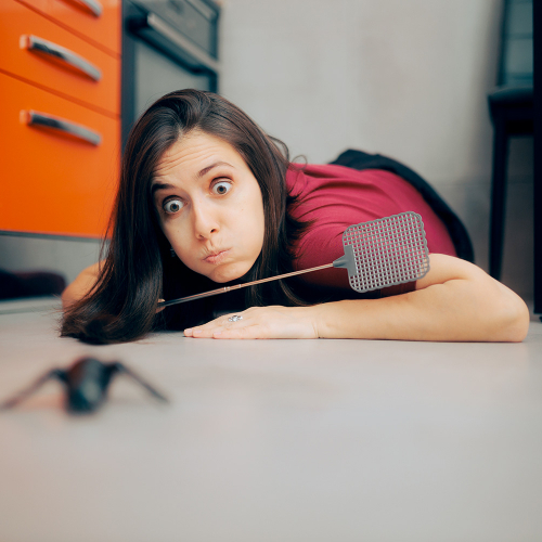 Femme prête à tuer un insecte avec une tapette